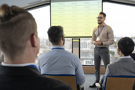 Instructor leading an on-site training session with employees inside a company workspace